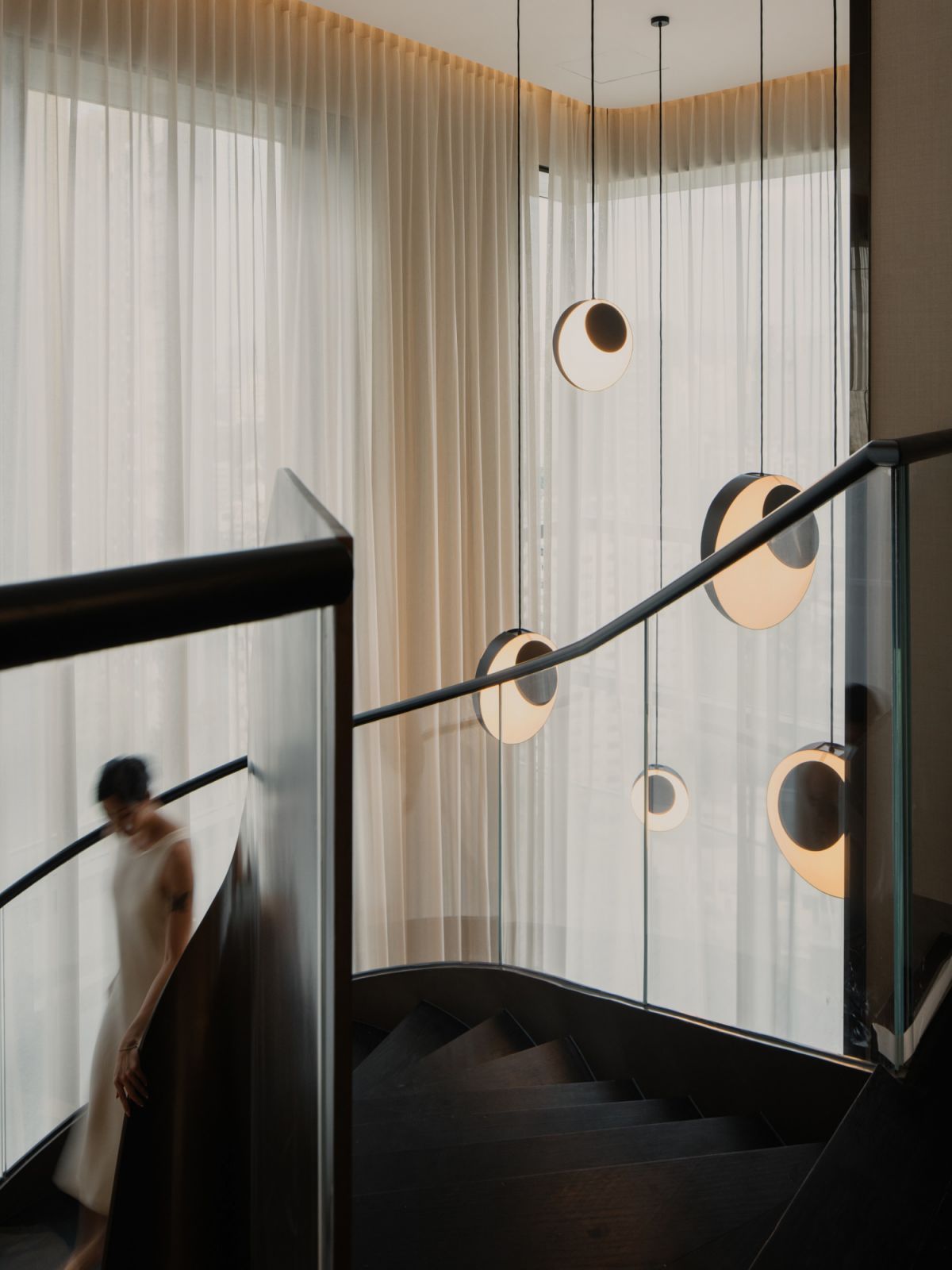 The staircase incorporates glass balustrades, exuding a sense of lightness