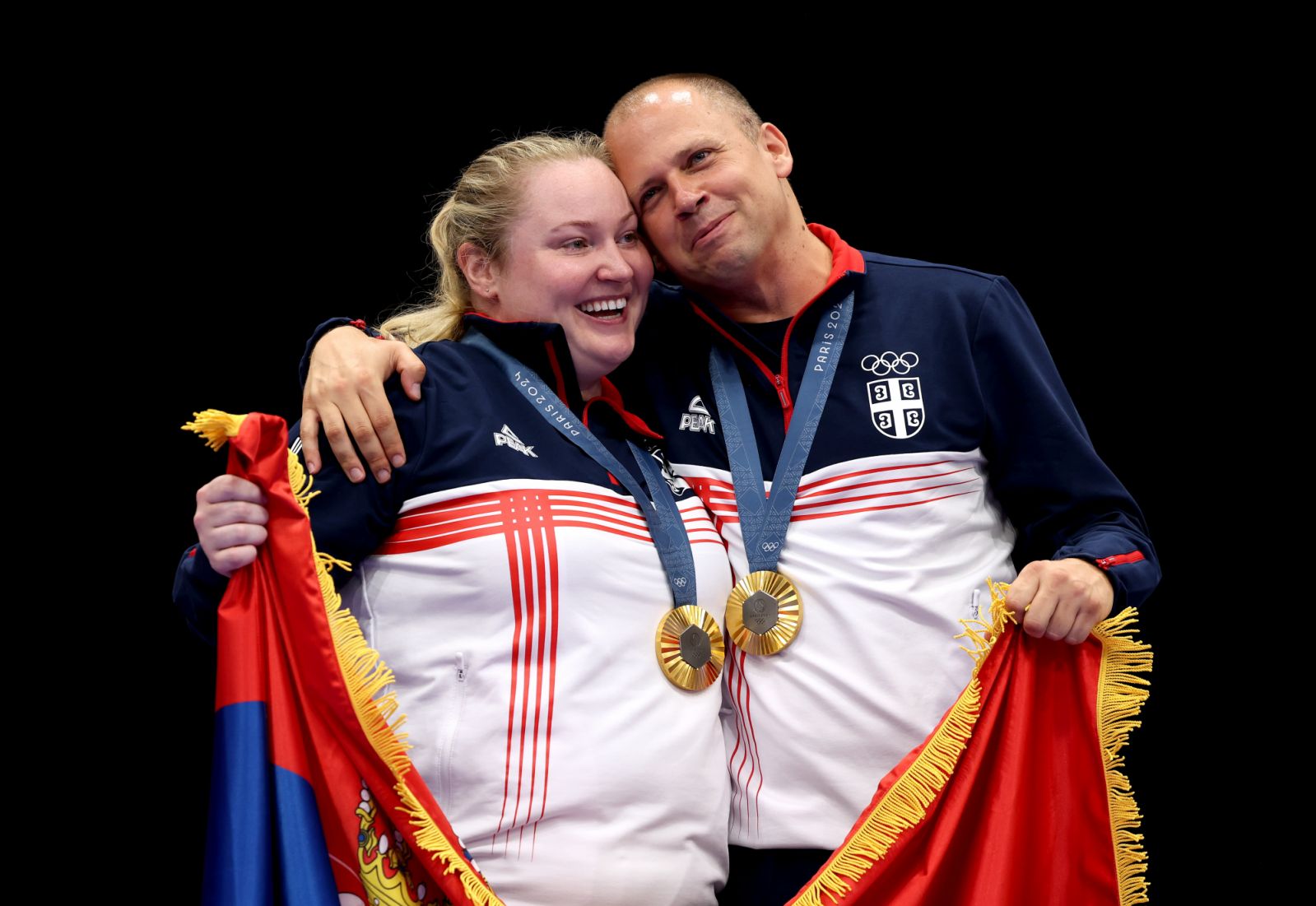 CHATEAUROUX, FRANCE - JULY 30: Gold medalists Zorana Arunovic and Damir Mikec of Team Serbia celebrate on the podium during the Shooting 10m Air Pistol Mixed Team medal ceremony  on day four of the Olympic Games Paris 2024 at Chateauroux Shooting Centre on July 30, 2024 in Chateauroux, France. (Photo by Charles McQuillan/Getty Images)