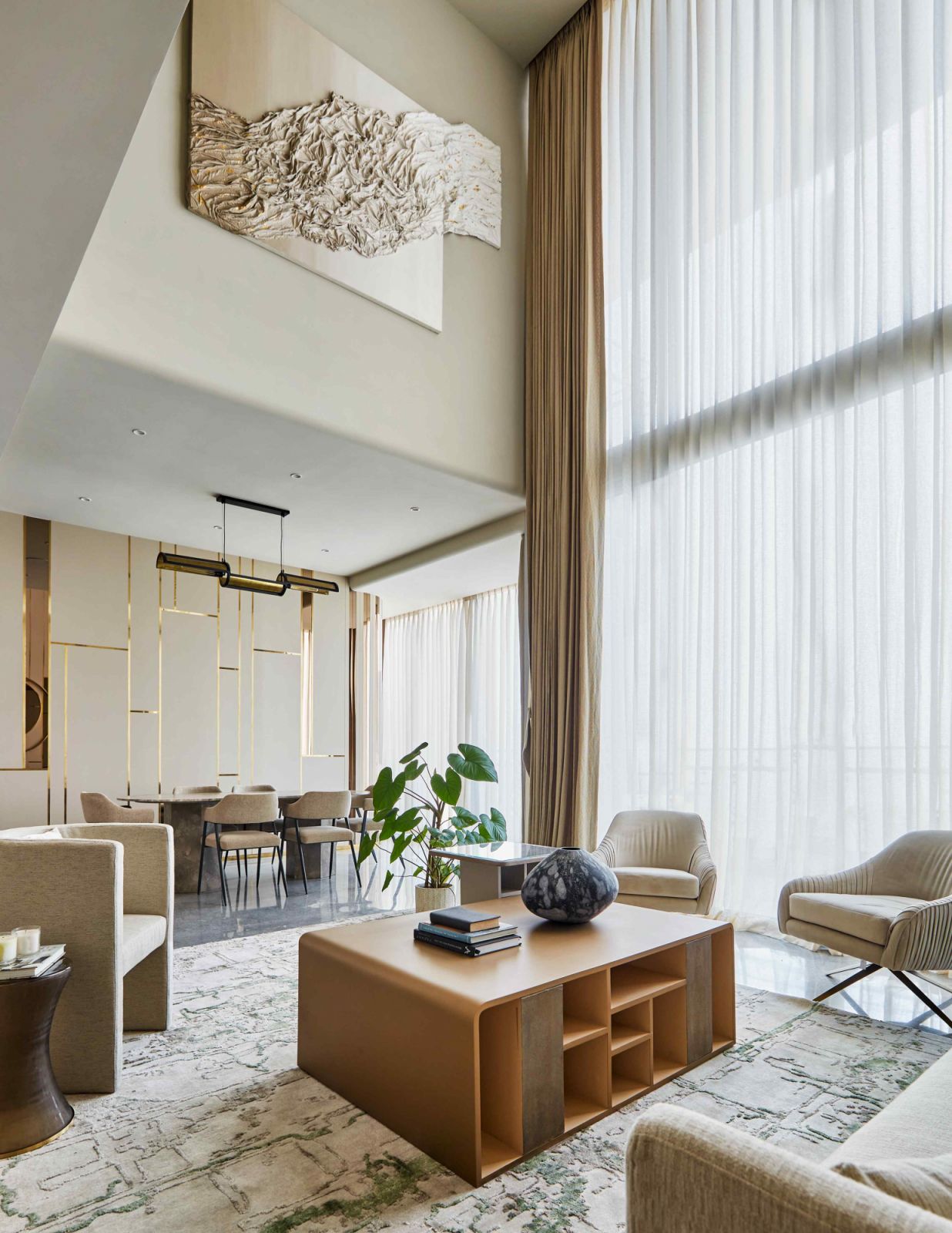 The double-ceilinged living room bathed in natural light from the balcony